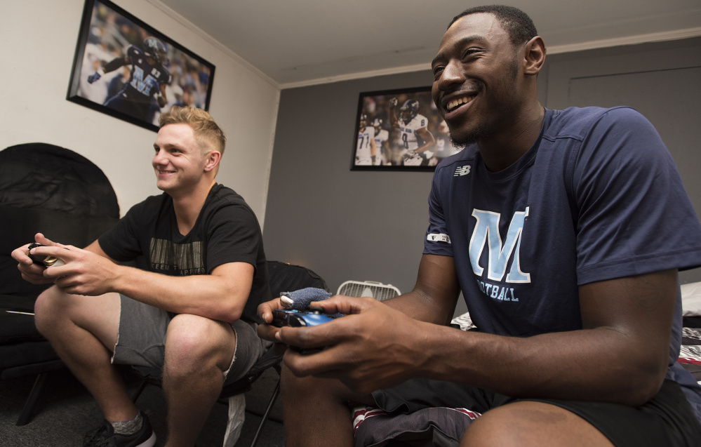 Maine quarterback Dan Collins, left, and receiver Jaleel Reed have built a friendship not just through football but long rides between Orono and the Philadelphia area. And, of course, their love of video games, especially FIFA, the EA soccer game.