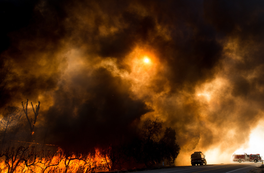 Firefighters battle a wildfire as it crosses Cajon Boulevard in Keenbrook, Calif., on Aug. 17. From June to August, there were at least 10 different weather disasters that each caused more than $1 billion in losses.