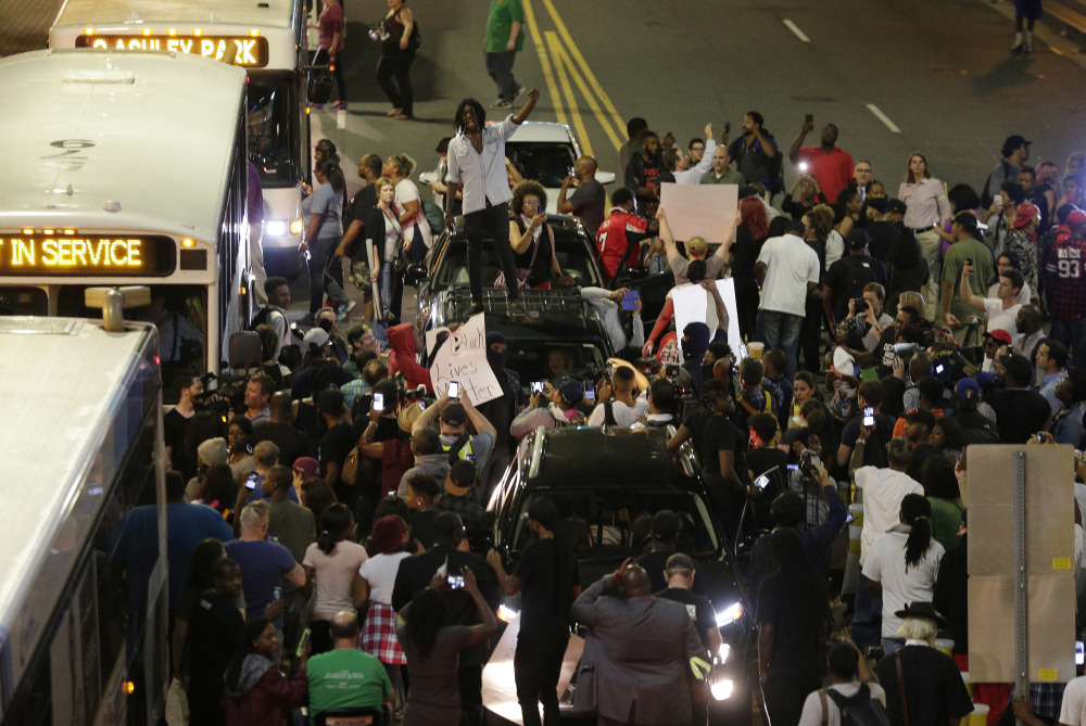 Demonstrators in Charlotte, N.C., protest Wednesday night against the fatal police shooting of Keith Lamont Scott. Protesters rushed police in riot gear at a downtown Charlotte hotel and officers fired tear gas to disperse the crowd.