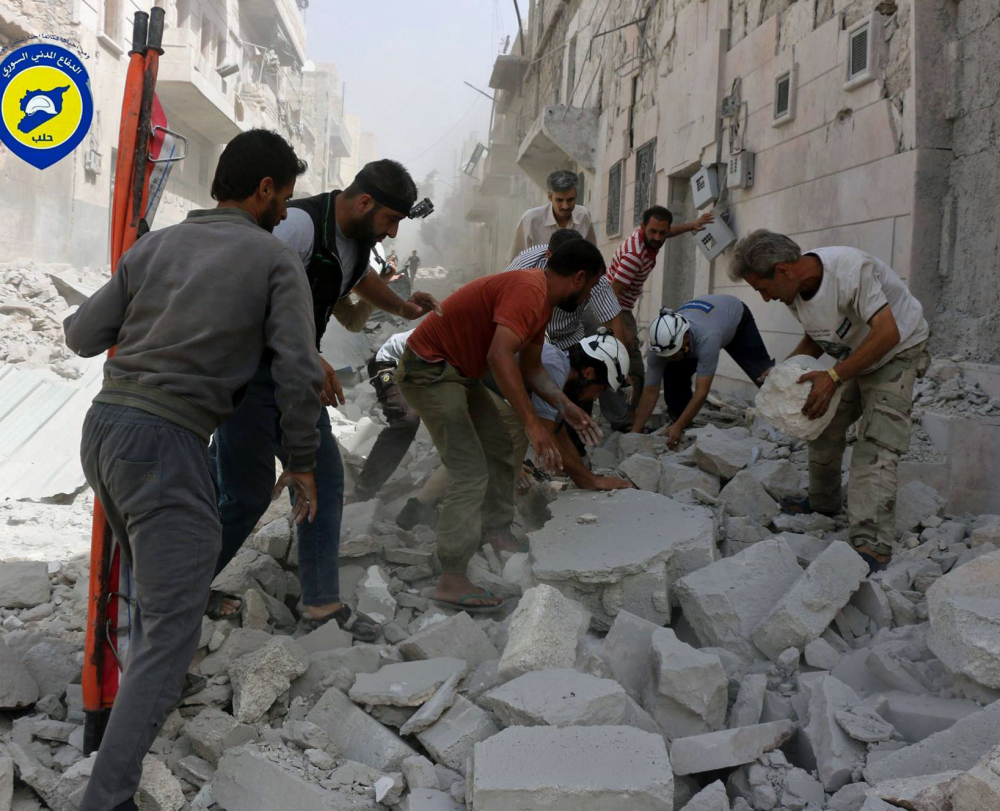 Rescue workers search through rubble after airstrikes in Aleppo, Syria, on Wednesday. A volunteer aid group said 24 were killed in a series of bombings in the besieged city.