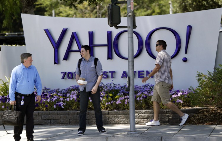People walk in front of a Yahoo sign at the company's headquarters in Sunnyvale, Calif., in 2014. Yahoo on Thursday confirmed a data breach that dates back to late 2014.