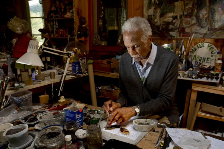 Artist Ashley Bryan, then 91, works with sea glass to make art at his workshop on Little Cranberry Island in 2014. Bryan has visited the island to create art since 1946 and retired there in the 1980s.