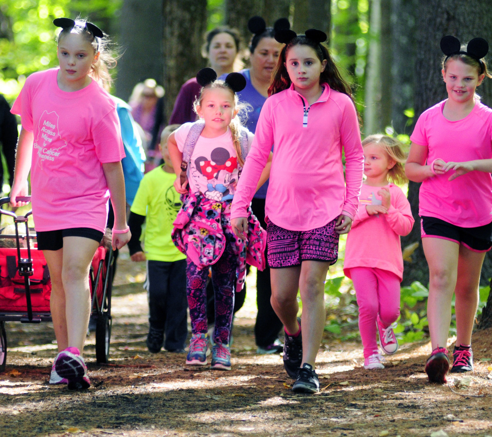 Children walk through the woods during the Miles Across Maine for Breast Cancer Awareness event Saturday in Augusta. Some wore Mickey Mouse ears in memory of the event organizer's grandmother, who loved to take Disney vacations.