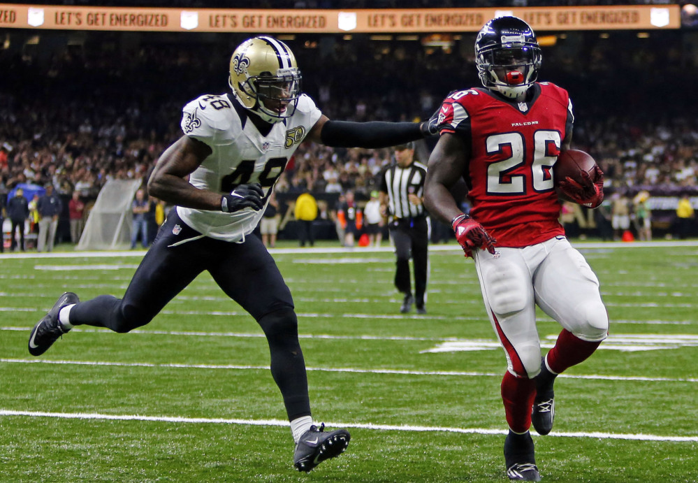 Falcons running back Tevin Coleman scores on a 6-yard touchdown run as the Saints' Vonn Bell gives chase in the third quarter of Atlanta's 45-32 win Monday in New Orleans. Coleman rushed for three touchdowns.
