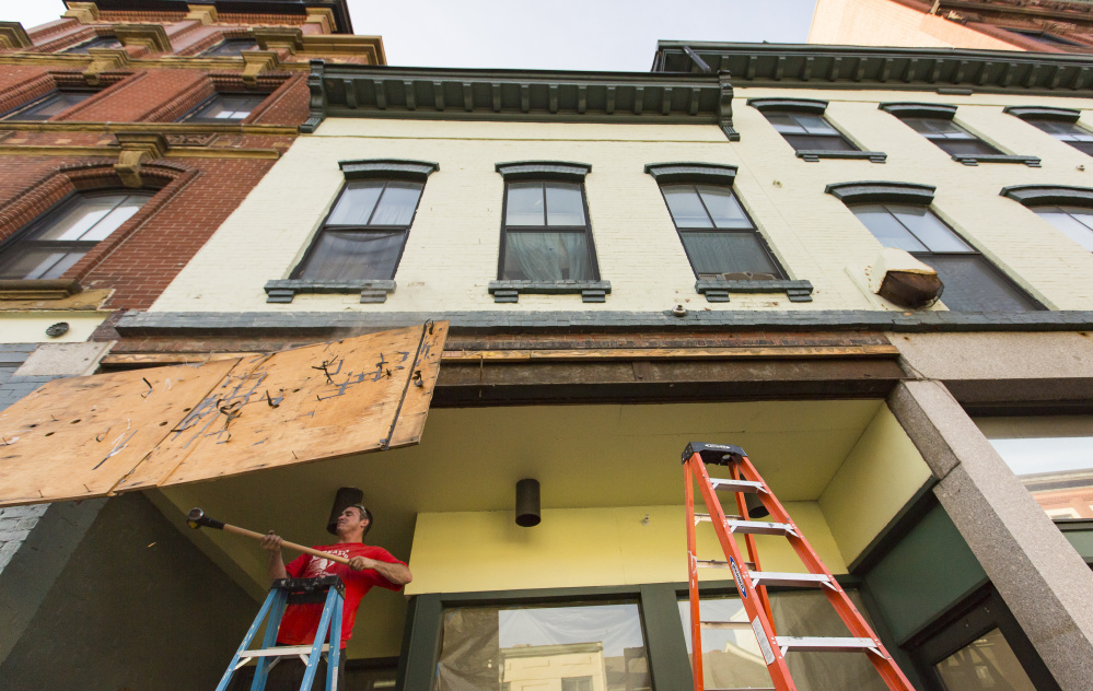PORTLAND, ME - SEPTEMBER 27: Josh Duball, a worker for Class Acts Property Management, demolishes the last remnant of the sign at the former site of Paul's Food Center, 585 Congress St. Flea-for-All, a purveyor of antiques and vintage good, is slated to open at the location on Oct. 6, according to store owner Erin Kiley. The store is currently located on Kennebec Street in Bayside (Photo by Ben McCanna/Staff Photographer)