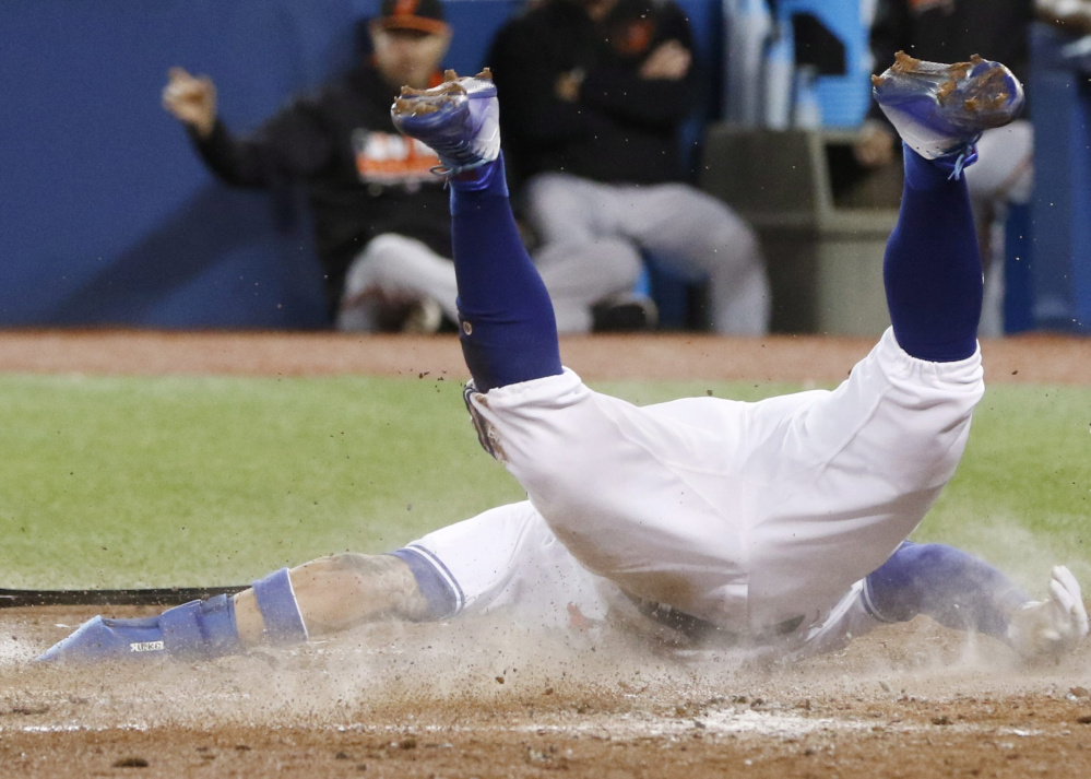 Toronto's Kevin Pillar slides home during the fifth inning of Tuesday's 5-1 triumph over Baltimore, giving the Blue Jays a two-game lead for the first wild-card slot in the AL.