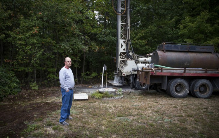 Bob Boynton of Standish stands next to his hand dug well on Sept. 23. Boynton hasn't run out of water in 25 years, but his well ran dry recently. Now, he has to drill a new well and is borrowing water from his neighbor via a garden hose. 