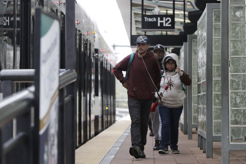 Commuters walk near a light rail train at the Hoboken Terminal Friday in New Jersey. Commuters are using alternative travel in and out of Hoboken a day after a commuter train crashed into the rail station, killing one person and injuring more than 100 people.