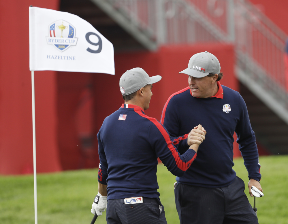 United States' Phil Mickelson celebrates with teammate Rickie Fowler after Fowler chipped in on the ninth to win the hole during a foresomes match at the Ryder Cup golf tournament Friday at Hazeltine National Golf Club in Chaska, Minn.