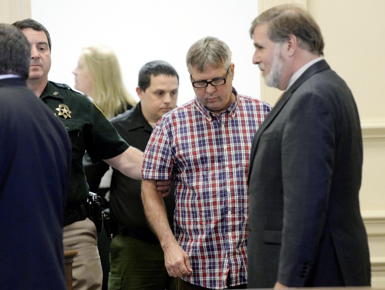 Bruce Akers, who is accused of killing of his neighbor with a machete, is led into the York County Superior Court in Alfred, where he pleaded not guilty on Tuesday.