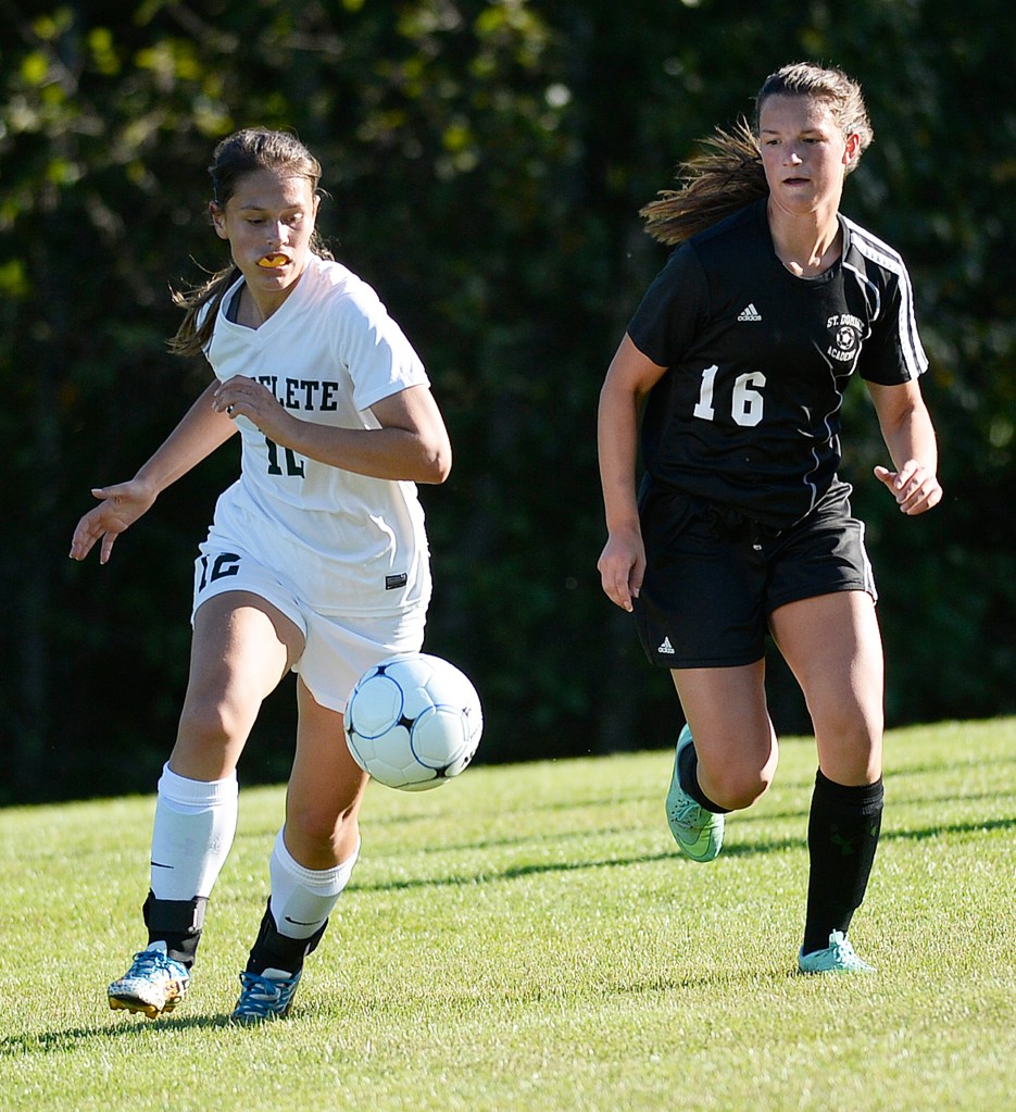 Waynflete's Clara Sandberg chases down the ball with Isabelle Frenette of St. Dom's Thursday.
Shawn Patrick Ouellette/Staff Photographer