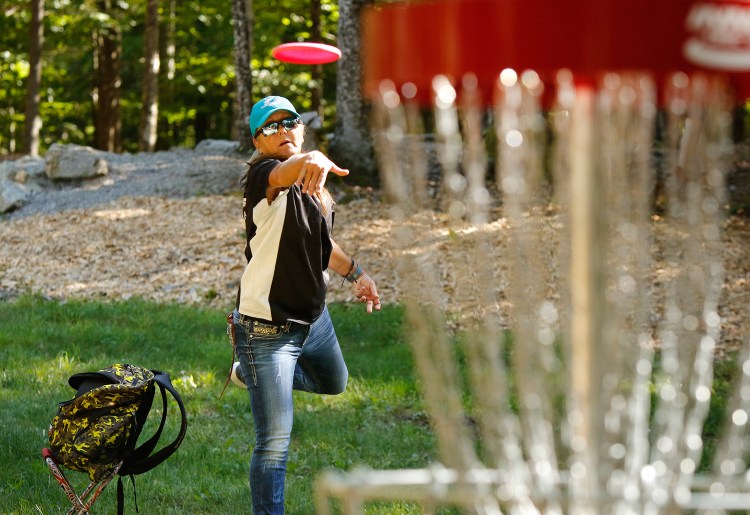 Sandy Gast of Florida releases a disc toward a basket Wednesday while practicing at the Sabattus Disc Golf Complex. Gast is a two-time world champion in the senior grand master category. Gregory Rec/Staff Photographer