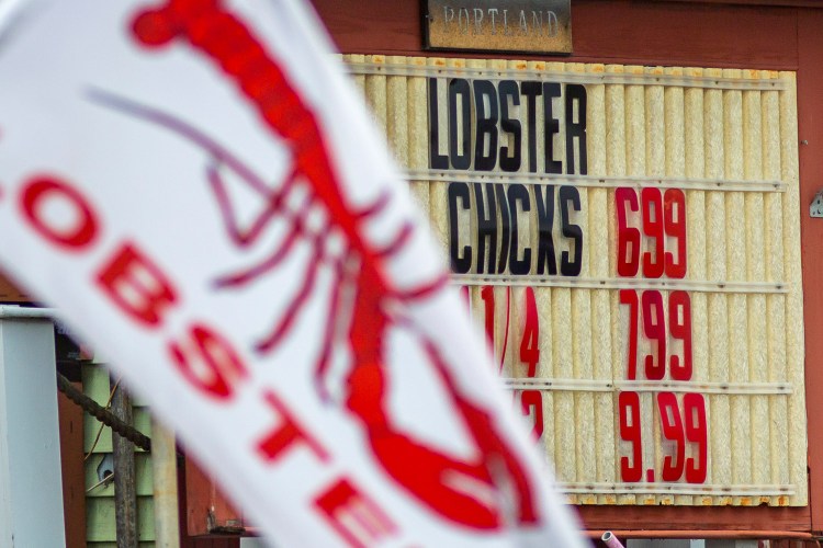 Lobster prices are posted outside Live Lobster Co., a seafood stand on Commercial Street in Portland. Lobster prices are the highest they have been in more than a decade. 
Ben McCanna/Staff Photographer