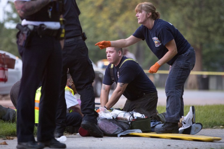 Members of the Chicago Fire Department work on a gunshot victim at the scene of a double shooting on Monday in the Englewood neighborhood of Chicago. Erin Hooley/Chicago Tribune via AP