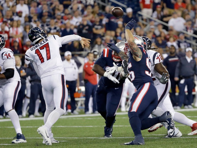 Texans quarterback Brock Osweiler passes under a heavy rush by the New England Patriots' defense on Sept. 22, 2016. The failed-so-far $72 million man faces off this weekend against the Oakland Raiders and their rookie third-string quarterback Connor Cook, who will be making his first NFL start. <em>Associated Press/Elise Amendola</em>
