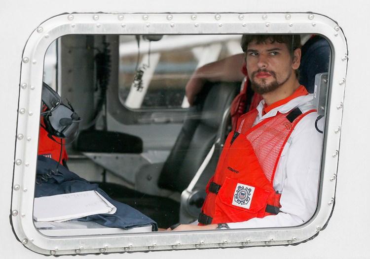 Nathan Carman arrives in a small boat at the U.S. Coast Guard station in Boston Tuesday. Carman spent a week at sea in a life raft before being rescued by a passing freighter. <em>Michael Dwyer/Associated Press</em>