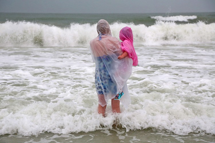 Lisa Bolton, of Manchester, England, holds her daughter as they watch the surf in Clearwater Beach, Fla., on Wednesday. <em>Douglas R. Clifford/Tampa Bay Times via AP</em>