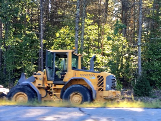 A stolen front-end loader sits on the side of the Maine Turnpike after it hit several cars on Monday morning. Photo by WCSH-TV