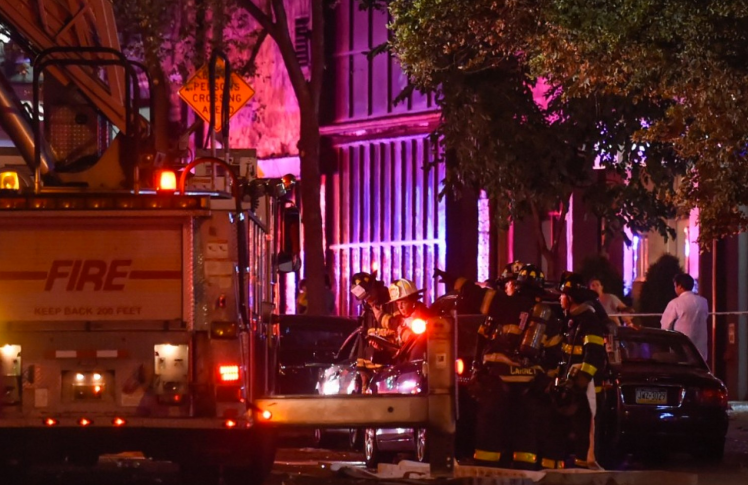 New York City firefighters stand near the site of an explosion in the Chelsea neighborhood of Manhattan on Saturday night. Rashid Umar Abbasi/Reuters