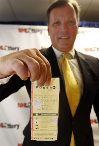 Charlie McIntyre, executive director of the New Hampshire Lottery Commission, holds the winning $487 million Powerball ticket from the July 30 drawing during a news conference Monday in Concord, N.H. Jim Cole/Associated Press