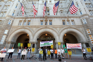 Protesters hold signs outside the new Trump International Hotel on its opening day in Washington Monday. Kevin Lamarque/Reuters
