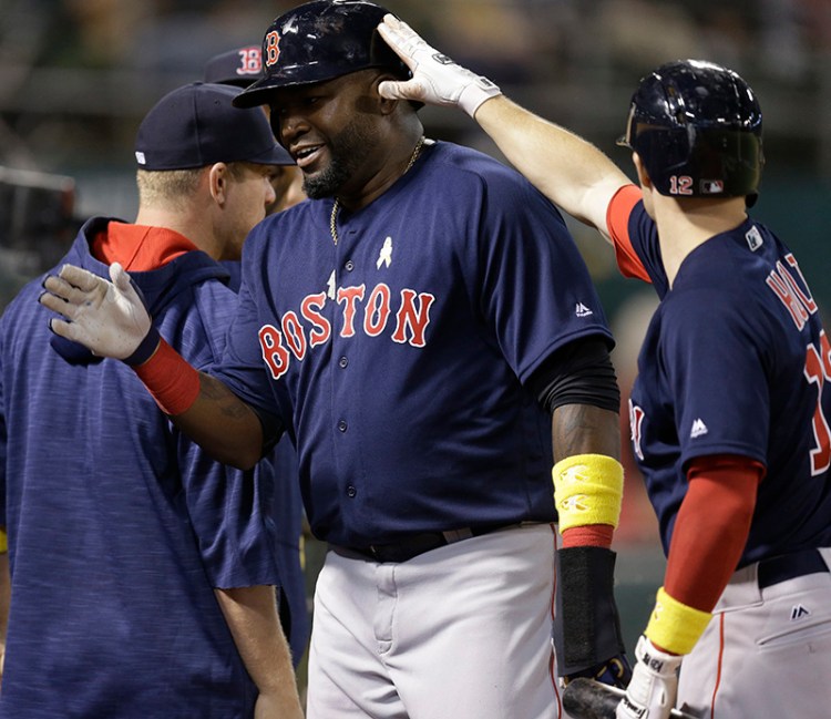 Boston Red Sox's David Ortiz is congratulated by Brock Holt, right, after scoring against the Oakland Athletics during the fifth inning.