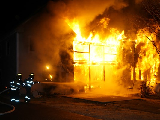 An apartment building at 54 Beal St. in Norway is engulfed in flames Monday night.  <em>Photo courtesy of WCSH</em>