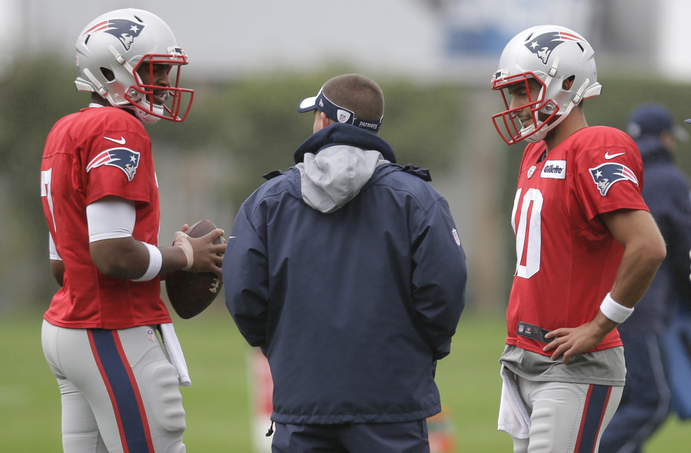 Patriots quarterbacks Jacoby Brissett, left, and Jimmy Garoppolo speak with offensive coordinator Josh McDaniels during practice Wednesday. Both players are dealing with injuries, and the Patriots haven't announced a starter.