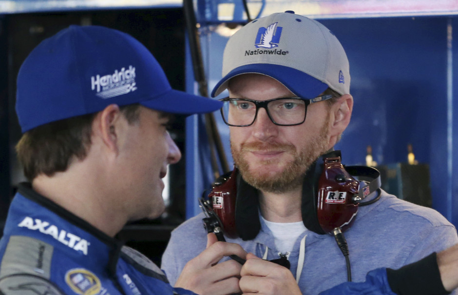 Dale Earnhardt Jr., right, who is recovering from a concussion, listens to Jeff Gordon  as they stand in the garage area before practice for Sunday's Sprint Cup race at Dover International Speedway. Gordon came out of retirement to fill in for the injured Earnhardt.