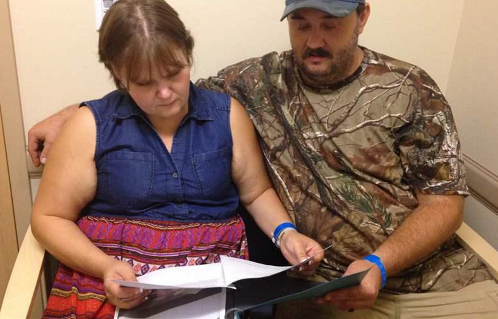 Jillian and Glen Coleman look over schedules at a clinic in Huntington, W.Va. The public favors spiritual-based recovery programs over medications that have proved helpful.