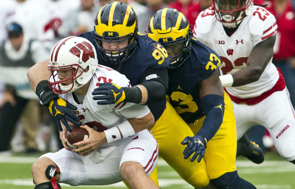Wisconsin quarterback Alex Hornibrook is sacked by Michigan defensive tackle Ryan Glasgow, center, and Taco Charlton, 33, in the second quarter of Saturday's Big Ten game in Ann Arbor, Mich., won by the Wolverines.