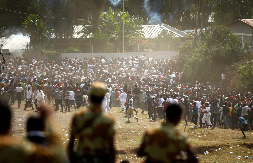 Protesters run from tear gas launched by security personnel during the Irrecha, the thanksgiving festival of the Oromo people, in the town of Bishoftu in the Oromia region of Ethiopia on Sunday.