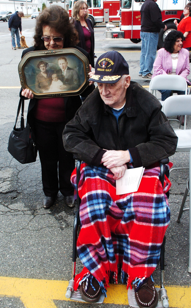 Gladys Goding holds a photograph that includes her father-in-law, Waterville firefighter Millard Goding, who died when a department firetruck he was in collided with a car while responding to a call in 1929. At right is Millard Goding's son Lawrence.