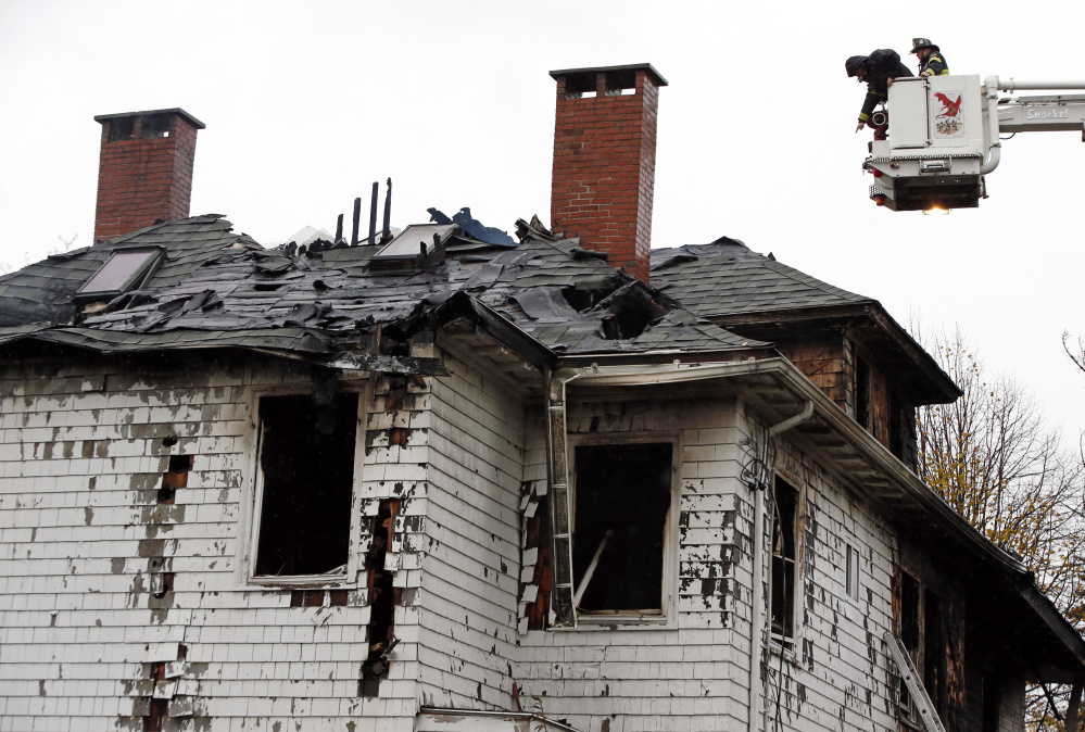Firefighters examine the charred apartment building at 20-24 Noyes St. in Portland after the fire on Nov. 1, 2014.