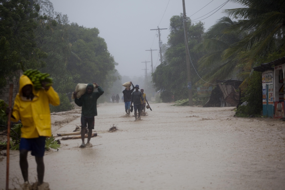 Residents walk in flooded streets as they return to their homes in Leogane, Haiti, on Tuesday. Hurricane Matthew slammed into Haiti's southwestern tip with 145 mph winds, tearing off roofs in the poor and largely rural area.