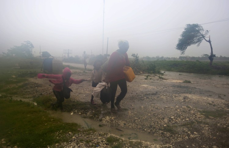 Residents head to a shelter in Leogane, Haiti, on Tuesday as Hurricane Matthew hits.