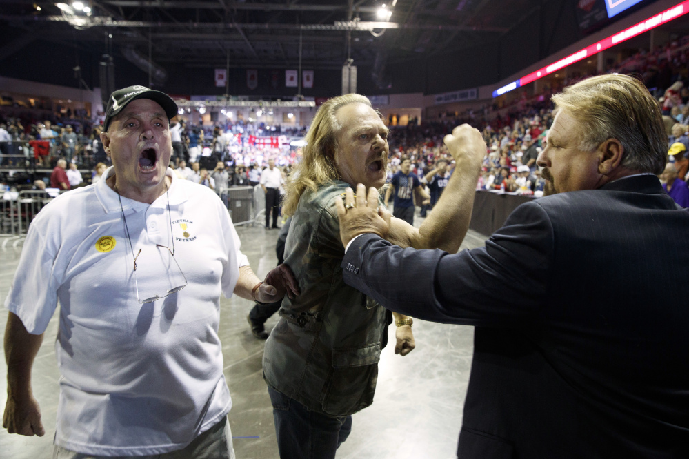 Supporters of Republican presidential candidate Donald Trump scream at a demonstrator as they follow him during a campaign rally Tuesday in Prescott Valley, Arizona.