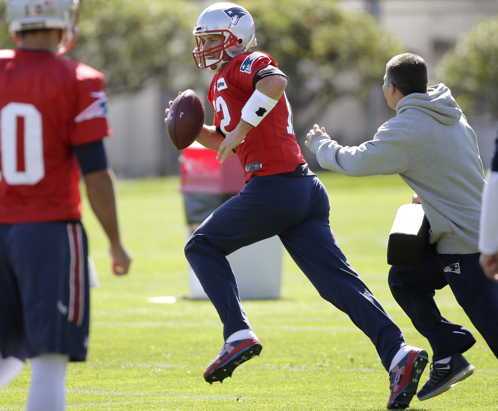 New England Patriots quarterback Tom Brady (12), center, performs field drills as quarterback Jimmy Garoppolo (10) looks on during an NFL football team practice Wednesday, Oct. 5, 2016, in Foxborough, Mass.