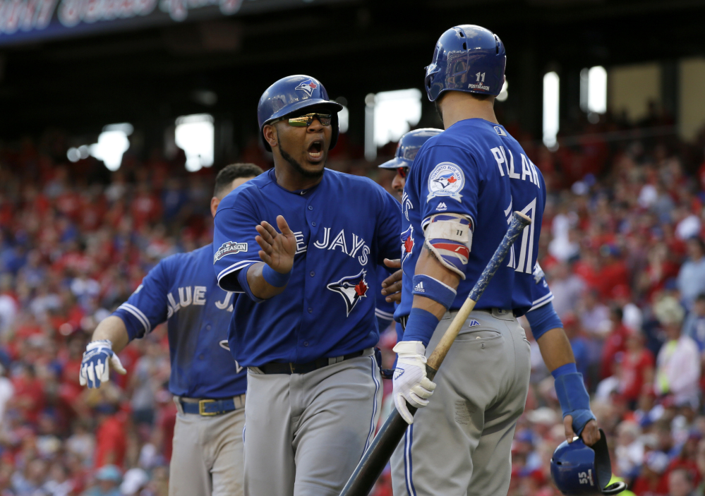 Toronto's Edwin Encarnacion celebrates with Kevin Pillar after scoring on a bases-clearing triple by Troy Tulowitzki in the third inning of Thursday's ALDS game at Arlington, Texas. Associated Press/LM Otero