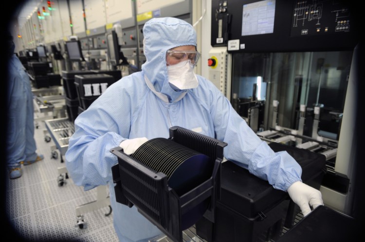 A worker at ON Semiconductor's Pocatello, Idaho, fabrication plant works with wafers in this 2011 photo. The wafers are the foundation of the integrated circuitry that become microchips.