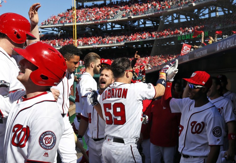 Washington's Jose Lobaton, 59, celebrates with his teammates after hitting a three-run home run in Game 2 of the NLDS on Sunday in Washington. The Nationals won, 5-2, to even the series at 1-1.