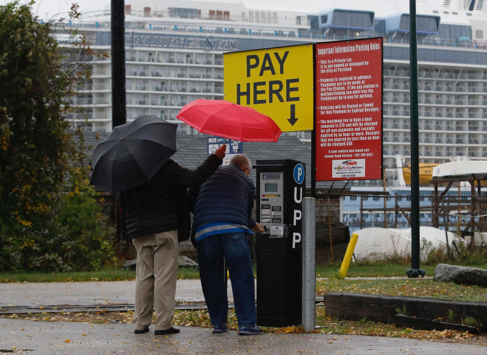 People pay for parking in a lot near the Anthem of the Seas on Sunday. The $940 million ship, which holds up to 4,905 passengers on its 18 decks, stopped in Portland several times this fall as cruise ships have become a plus for the state's tourism industry.