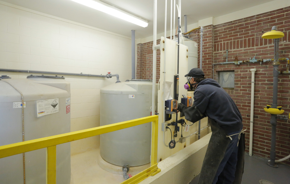 Randy Nichols checks the feed rate of hydrofluorosilicic acid, a type of fluoride, seen in tanks at left, as it is added to water at the Kennebunk, Kennebunkport and Wells Water District. A forum will be held Monday in Kennebunk to discuss an upcoming referendum in seven towns that asks residents if they want to continue to add fluoride to drinking water.
