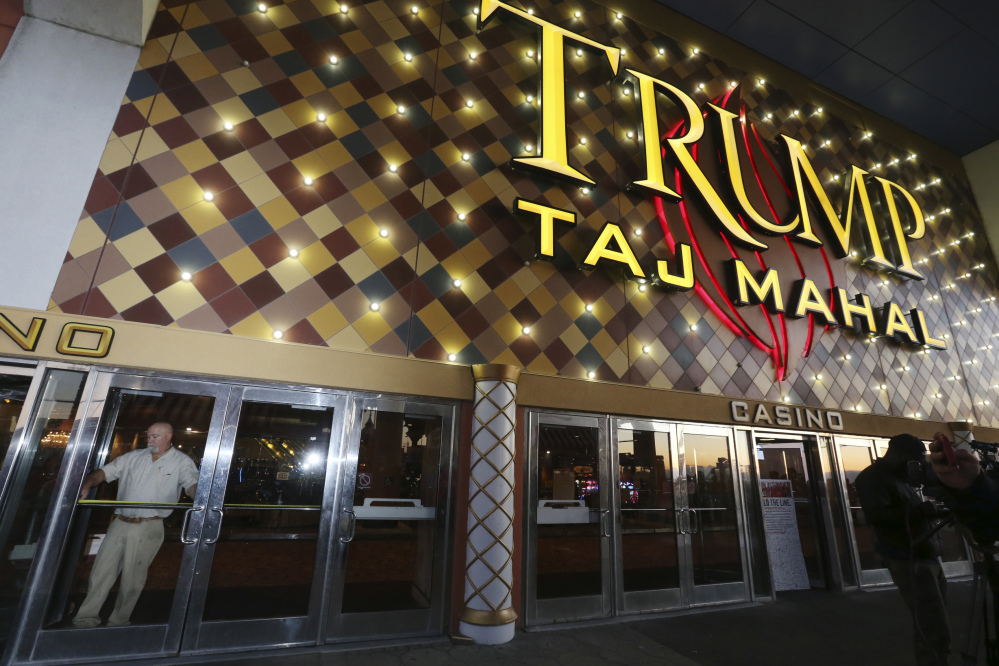 A worker measures the doorway to block the entrance at the Trump Taj Mahal on Monday in Atlantic City, N.J. The sprawling Boardwalk casino, with its soaring domes, minarets and towers built to mimic the famed Indian palace, shut down at 5:59 a.m., having failed to reach a deal with its union workers to restore health care and pension benefits that were taken away from them in bankruptcy court.