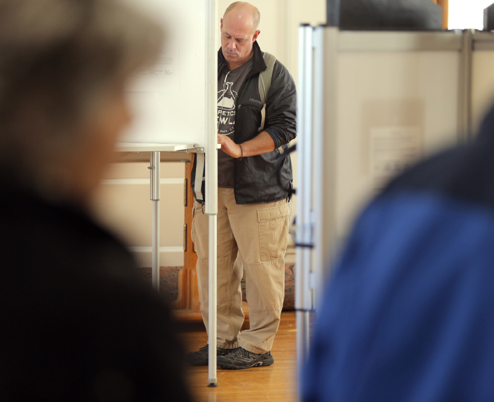 Gregory Seligman votes at City Hall in Portland on Tuesday. Seligman said he felt strongly about voting for Hillary Clinton.