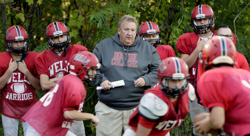 Wells football coach Tim Roche watches his team run drills during a practice last month. Roche has long limited the amount of contact in his practices, finding that it has reduced injuries in general for his teams, not just concussions.