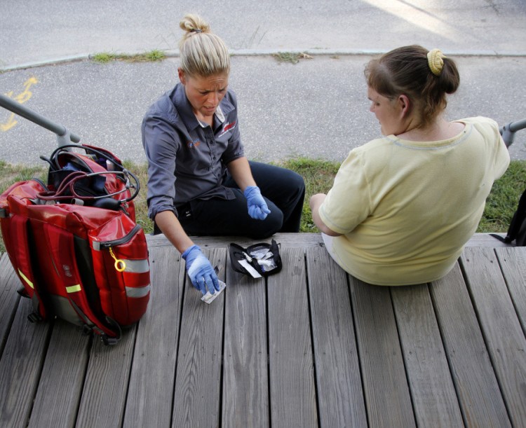 Daphne Russell, a community paramedic in Lewiston, meets with 36-year-old patient Keri Smith on the steps outside Smith's home.