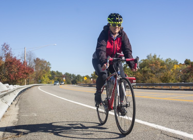 Sue Ellen Bordwell rides her bike on the Route 1 bridge in Yarmouth. Bordwell spends a lot of time advocating for biker and walker safety, and she has advocated for  improvements to the Route 1 bridge.