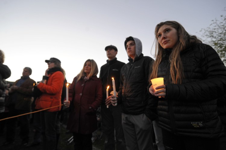 Mourners hold candles during a vigil attended by about 1,000 at Harwood Union High School in Duxbury, Vt., held for the teenaged victims killed in Saturday night's crash on Interstate 89 in Williston.