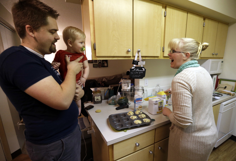 Shavonne Henry greets her 7-month-old son, Jordan, as her husband brings him into the kitchen. Unlike many of their peers, the Vancouver, Wash., couple in their mid-20s have savings in 401(k) accounts. "I feel pretty good about our future," said Shavonne.